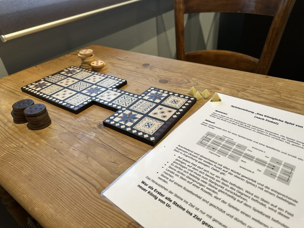 Ein altes Brettspiel, ähnlich Mühle oder Dame, mit Anleitung im Vordergrund